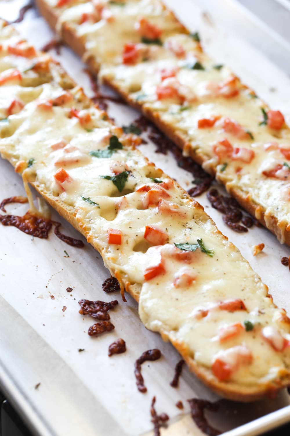 Baguette covered in cheese and topped with tomatoes