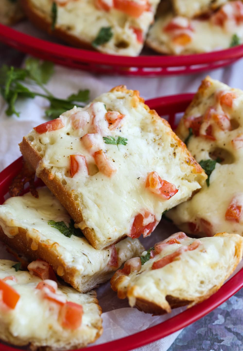 Cheesy Bread in a basket to serve topped with tomatoes and parsley