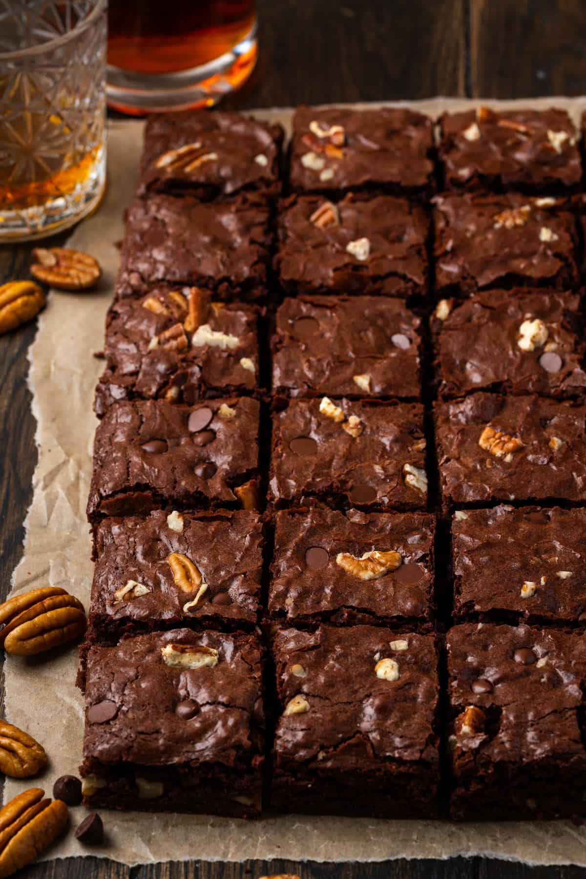 Cut the bourbon pecan brownies into squares on a lined cutting board.