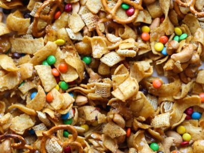 Frito Snack mix on a baking sheet with M&Ms, Fritos, pretzels, and chex cereal