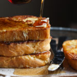 Pouring Maple Syrup over a Stack of Brioche French Toast
