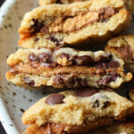 peanut butter cup cookie sandwiches on a platter broken in half