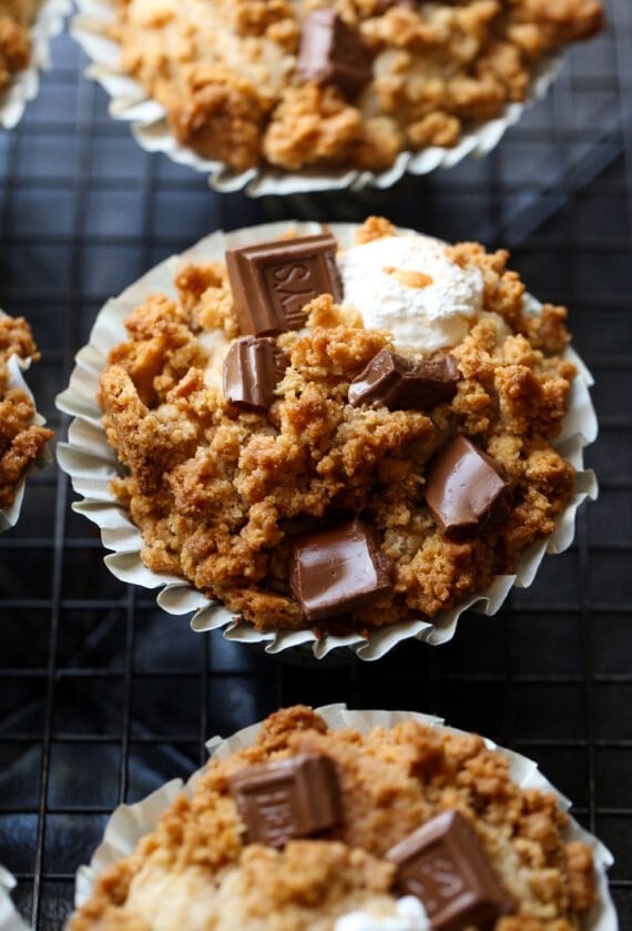 Muffin topped with graham cracker crumble and milk chocolate on a wire rack