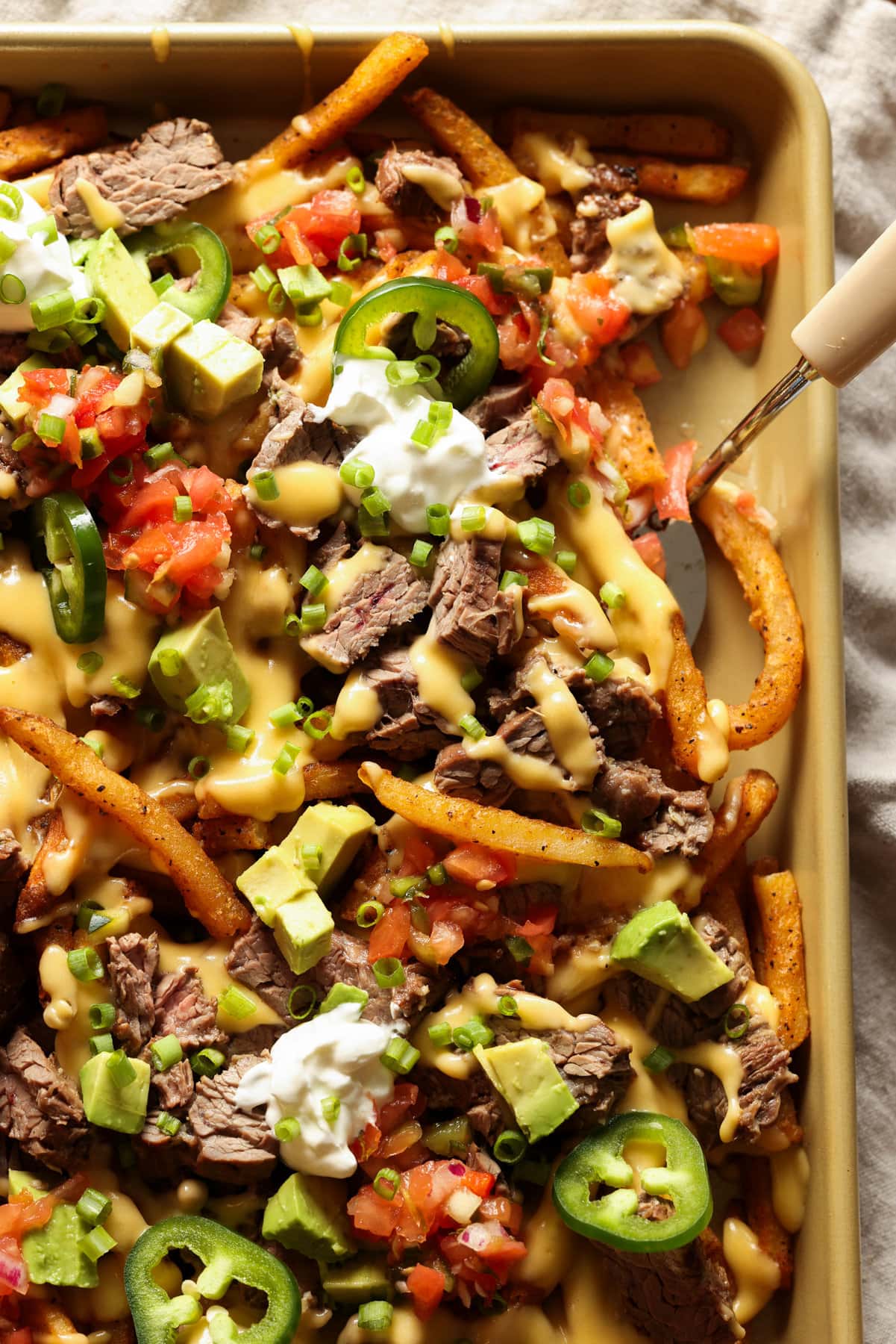 Carne Asada topped french fries with melted cheese and all the nacho toppings. 