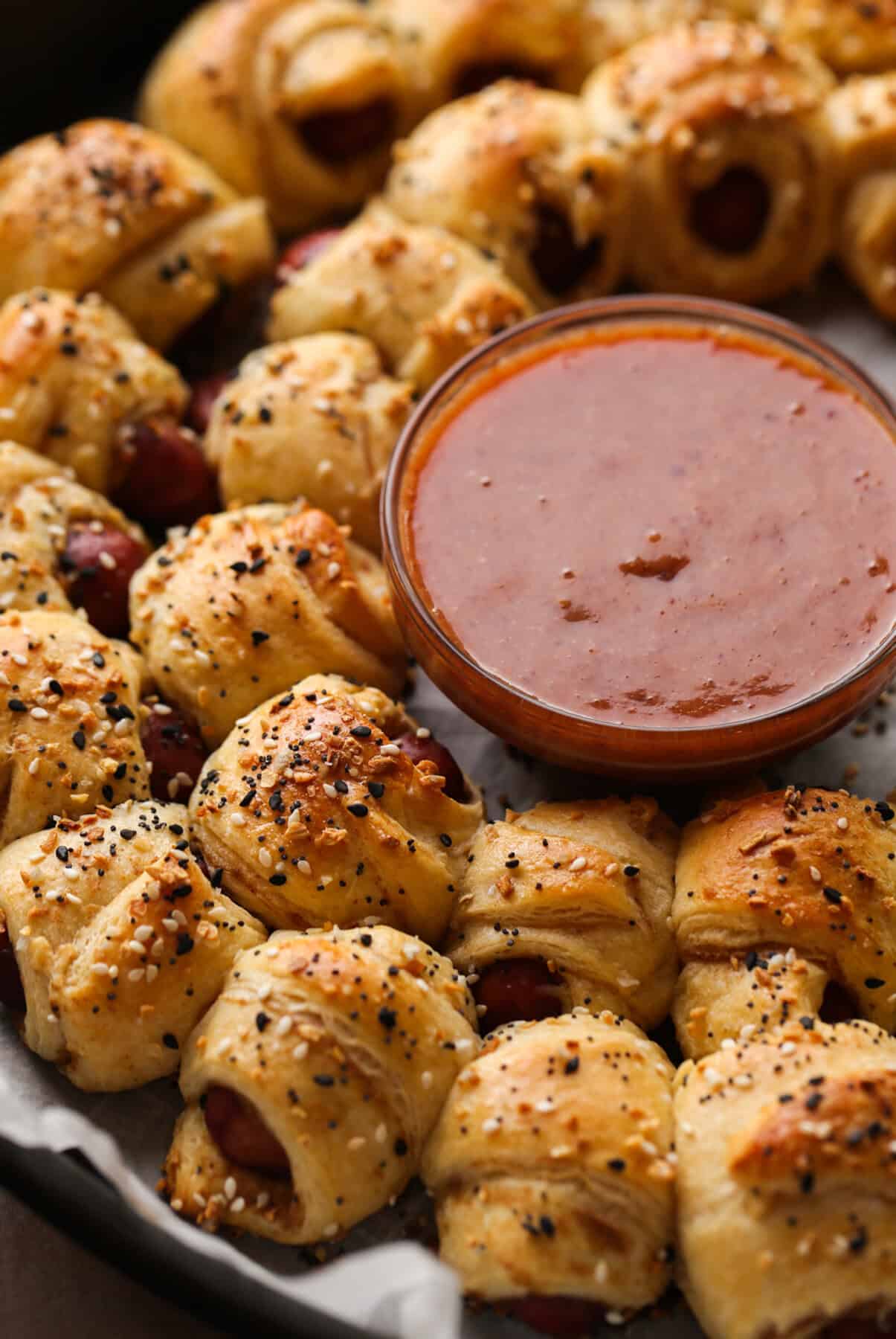 Pigs In a Blanket topped with everything seasoning and dipping sauce