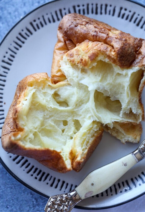 A Popover Split in Half on a White and Black Plate
