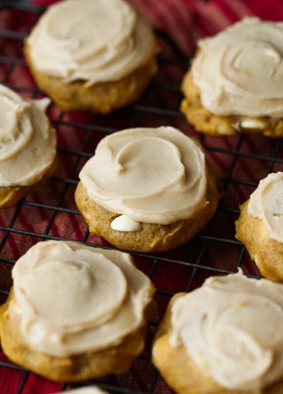 Pumpkin Cookies topped with frosting on a wire rack