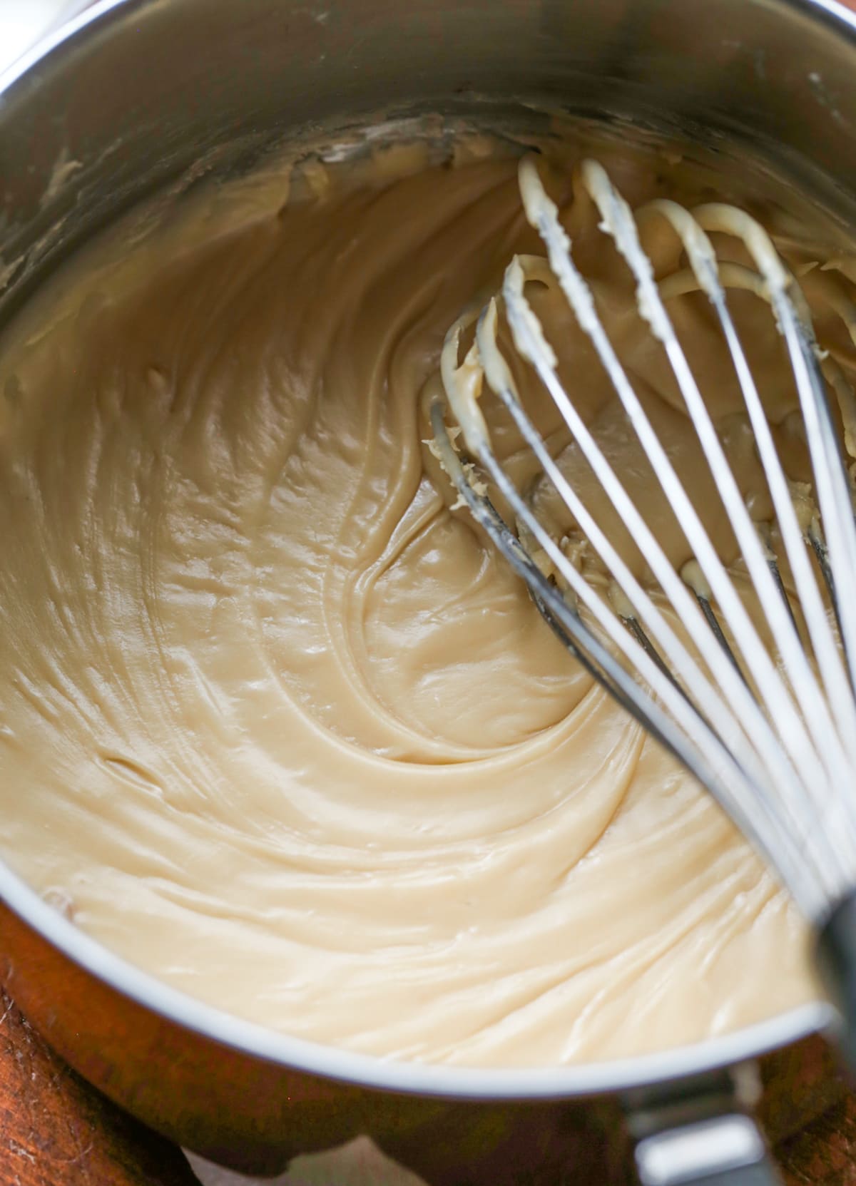 brown sugar icing in a saucepan with a whisk