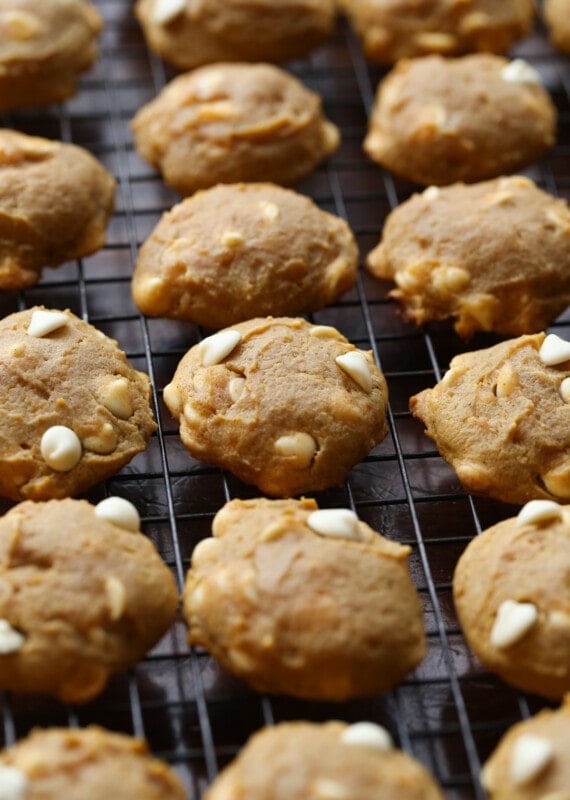 Pumpkin cookies cooling on a wire rack before spreading with icing.