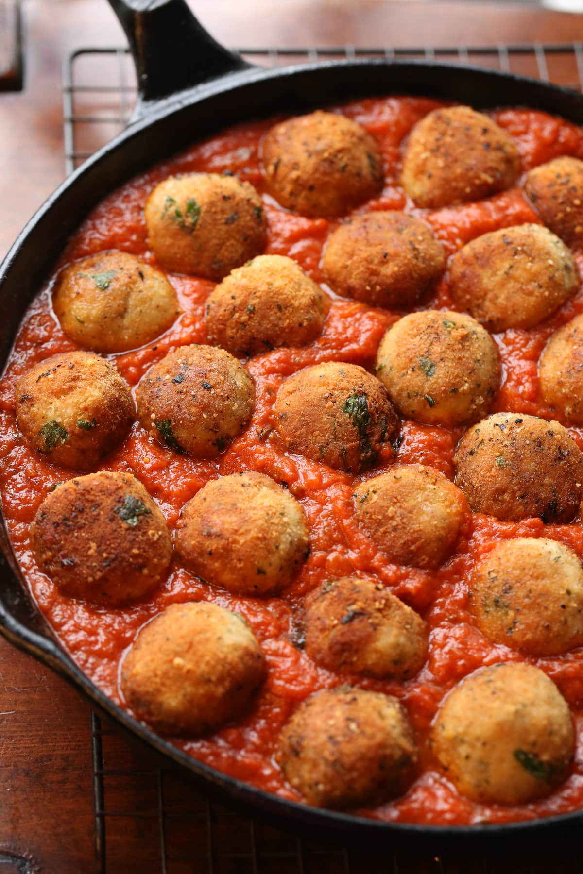 meatballs sitting in pasta sauce in a skillet