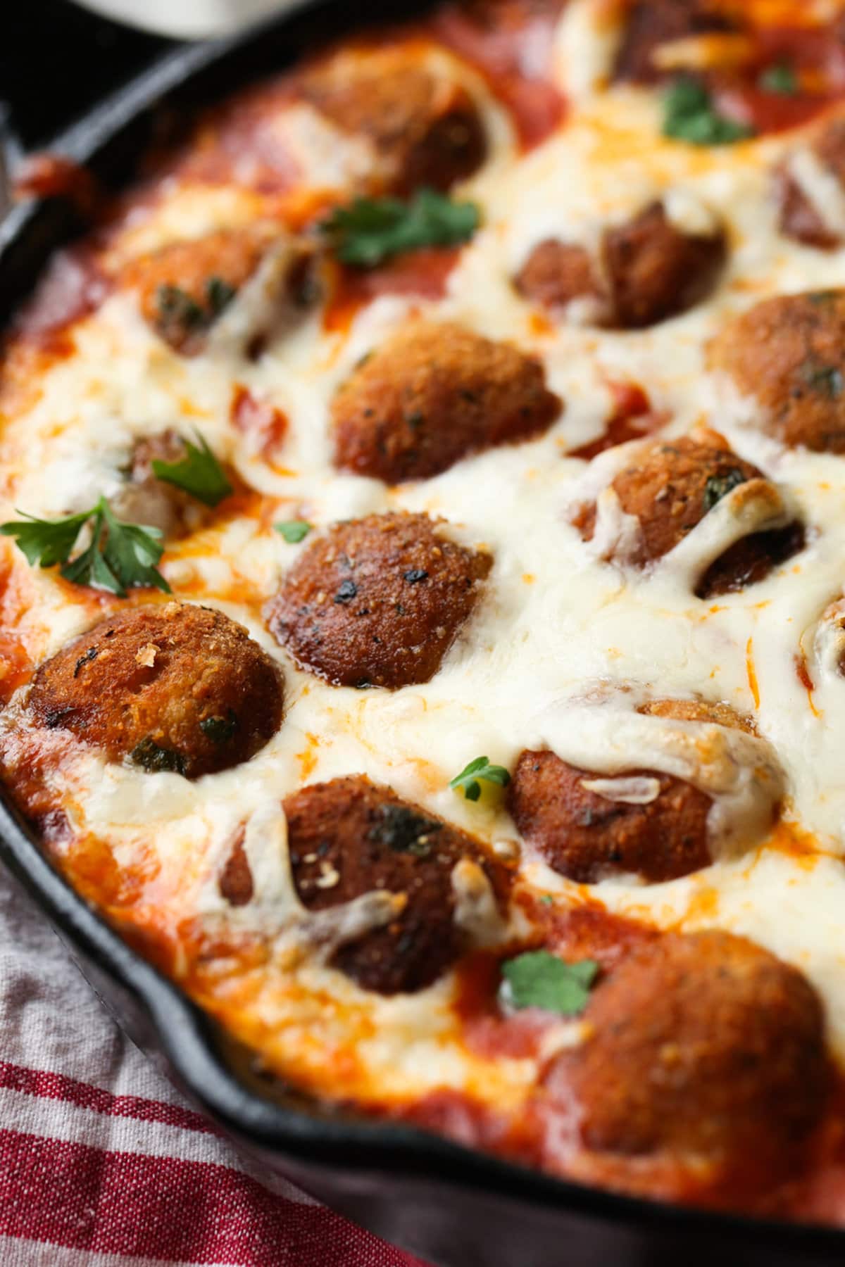 Breaded Chicken Meatballs in marinara sauce baked in a skillet topped with cheese