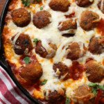 Chicken Parmesan Meatballs in a skillet topped with mozzarella cheese