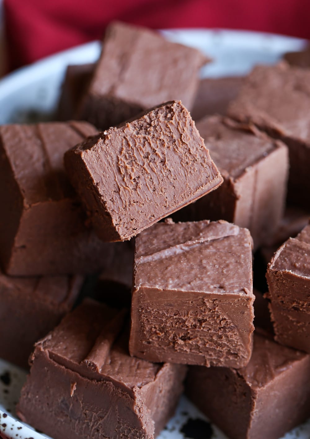 Chocolate fudge squares stacked in a bowl.