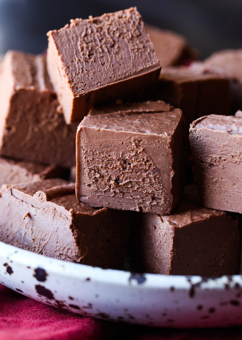 Chocolate fudge squares stacked in a bowl.