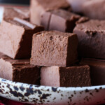 Chocolate fudge squares stacked in a bowl.