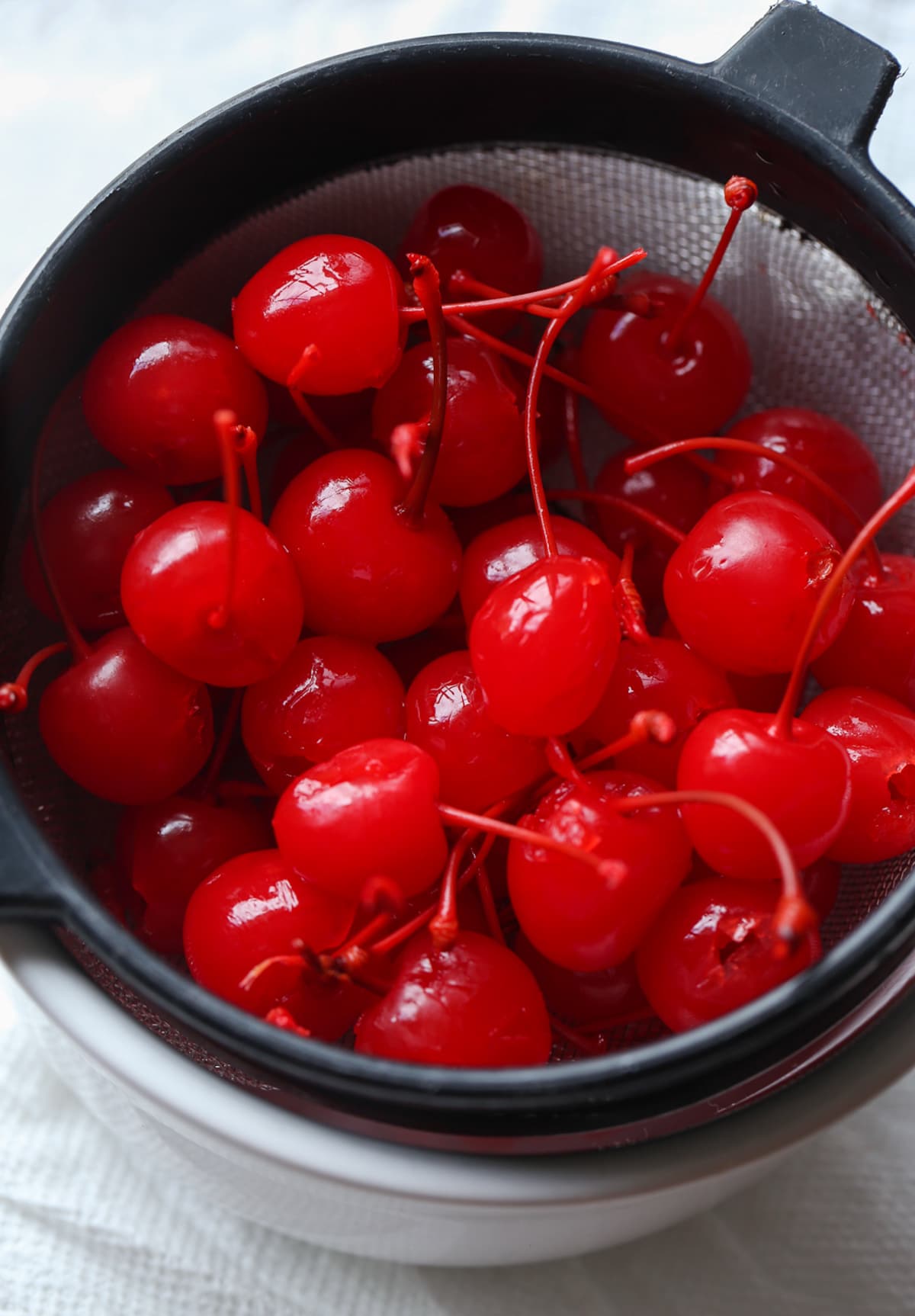 A bowl of Maraschino cherries with stems