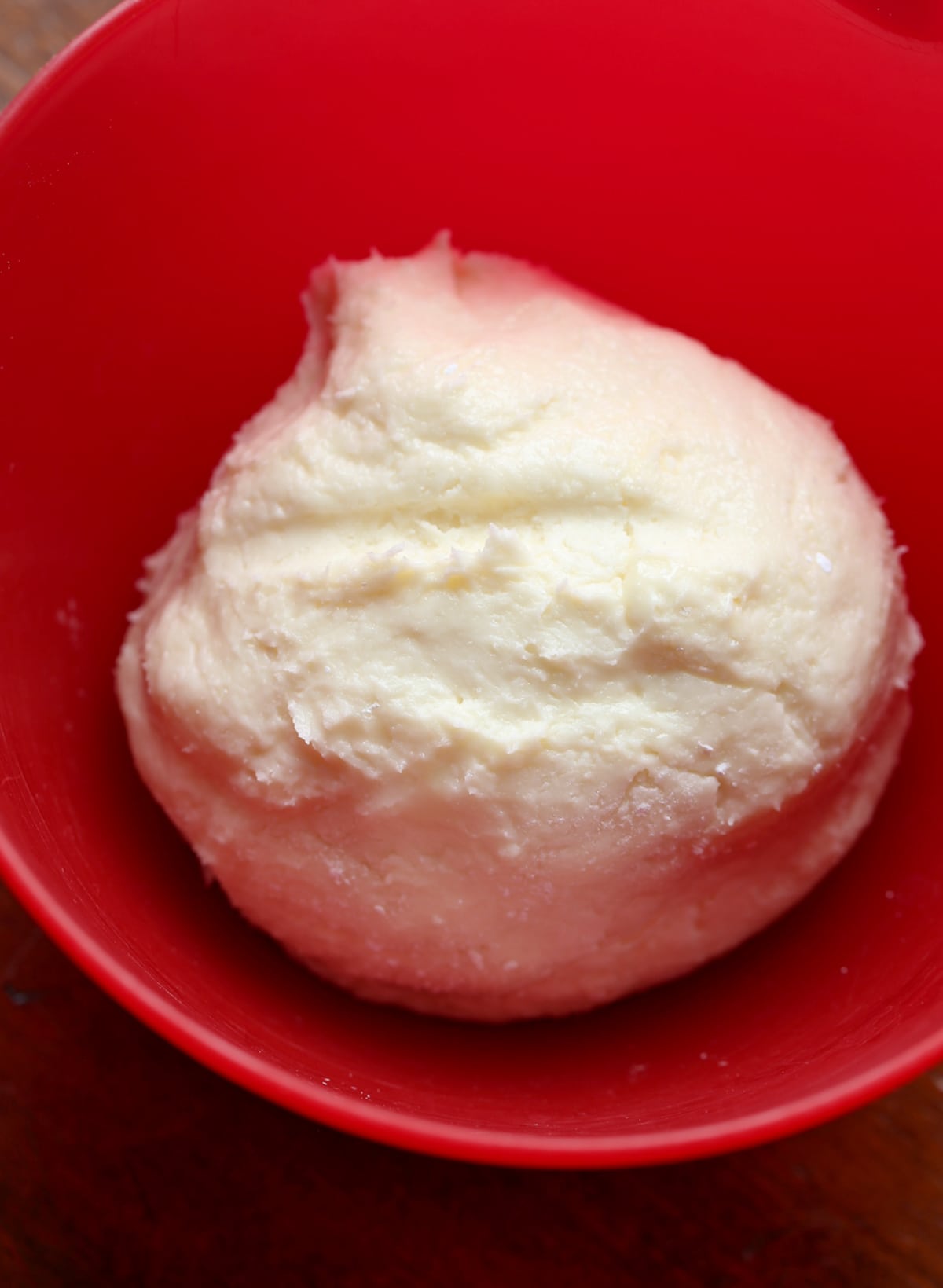 A mound of white fondant in a red bowl