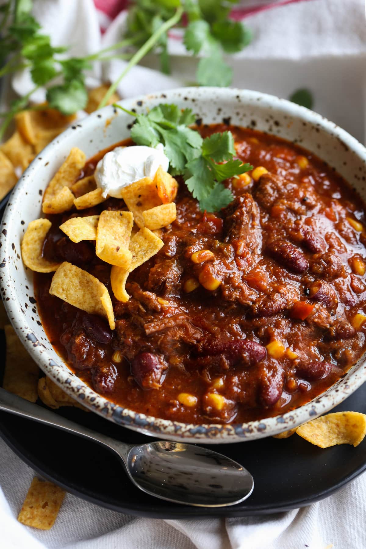 Chili topped with corn chips and basil