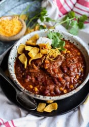 Chili in a bowl topped with Fritos and Sour Cream