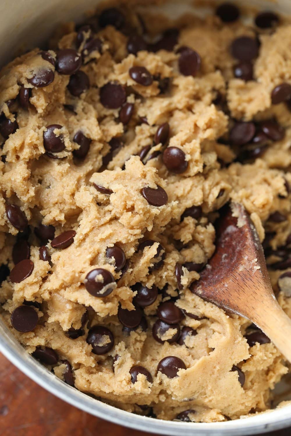 chocolate chip cookie dough with a wooden spoon