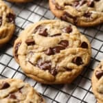 Brown Butter Chocolate Chip Cookies topped with flaked sea salt on a wire cooling rack