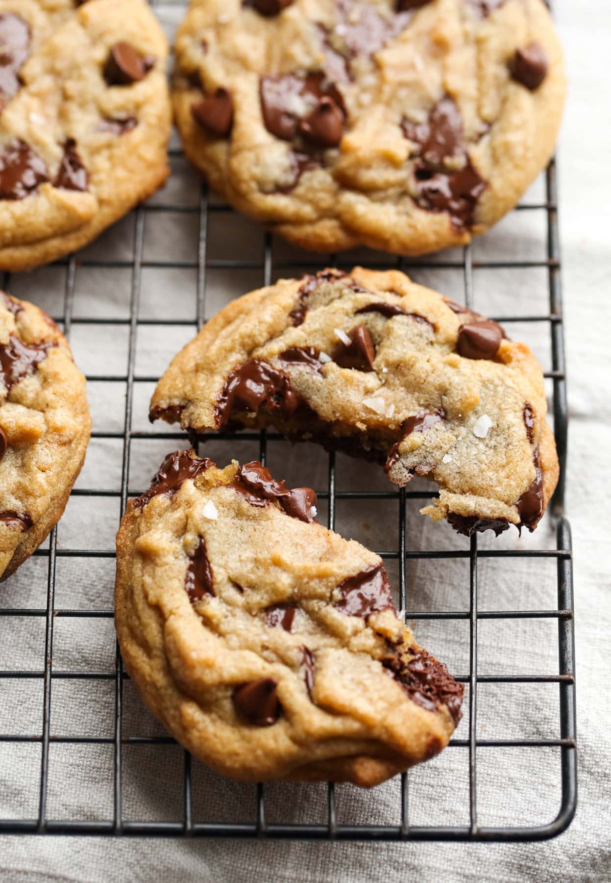 A Brown Butter Chocolate Chip Cookie broken in half on a wire cooling rack