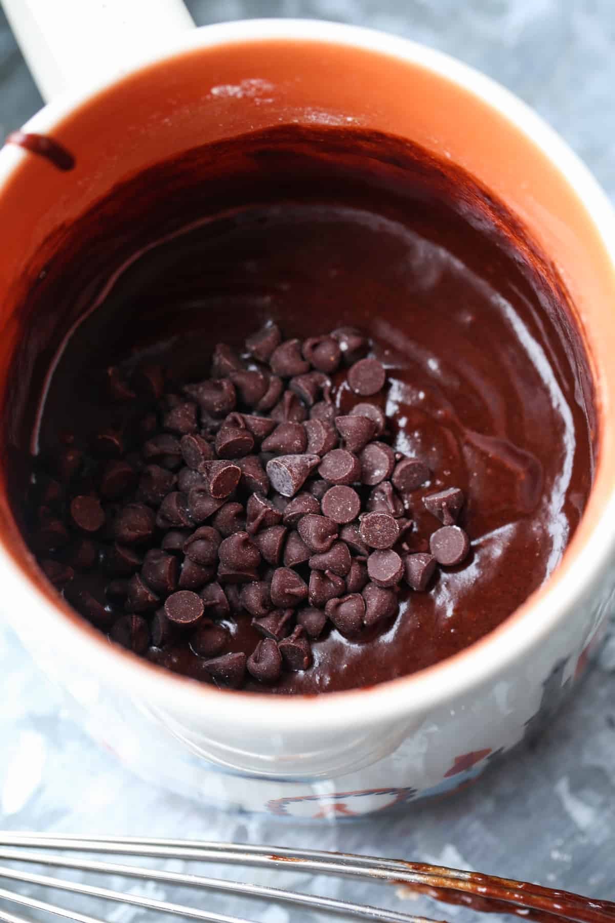 Brownie batter in a mug topped with mini chocolate chips