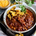 Chili topped with Fritos, cilantro, and sour cream