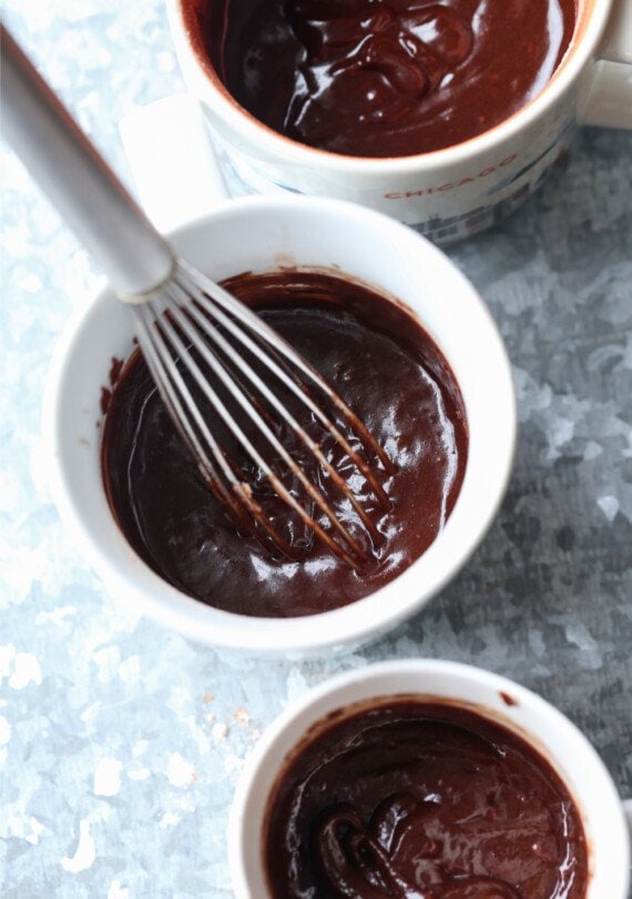 whisking brownie batter in a mug