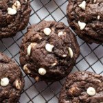 Chocolate Oreo cookies with white chocolate chips on a cooling rack