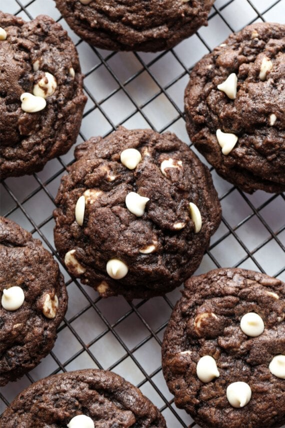 Chocolate Oreo cookies with white chocolate chips on a cooling rack