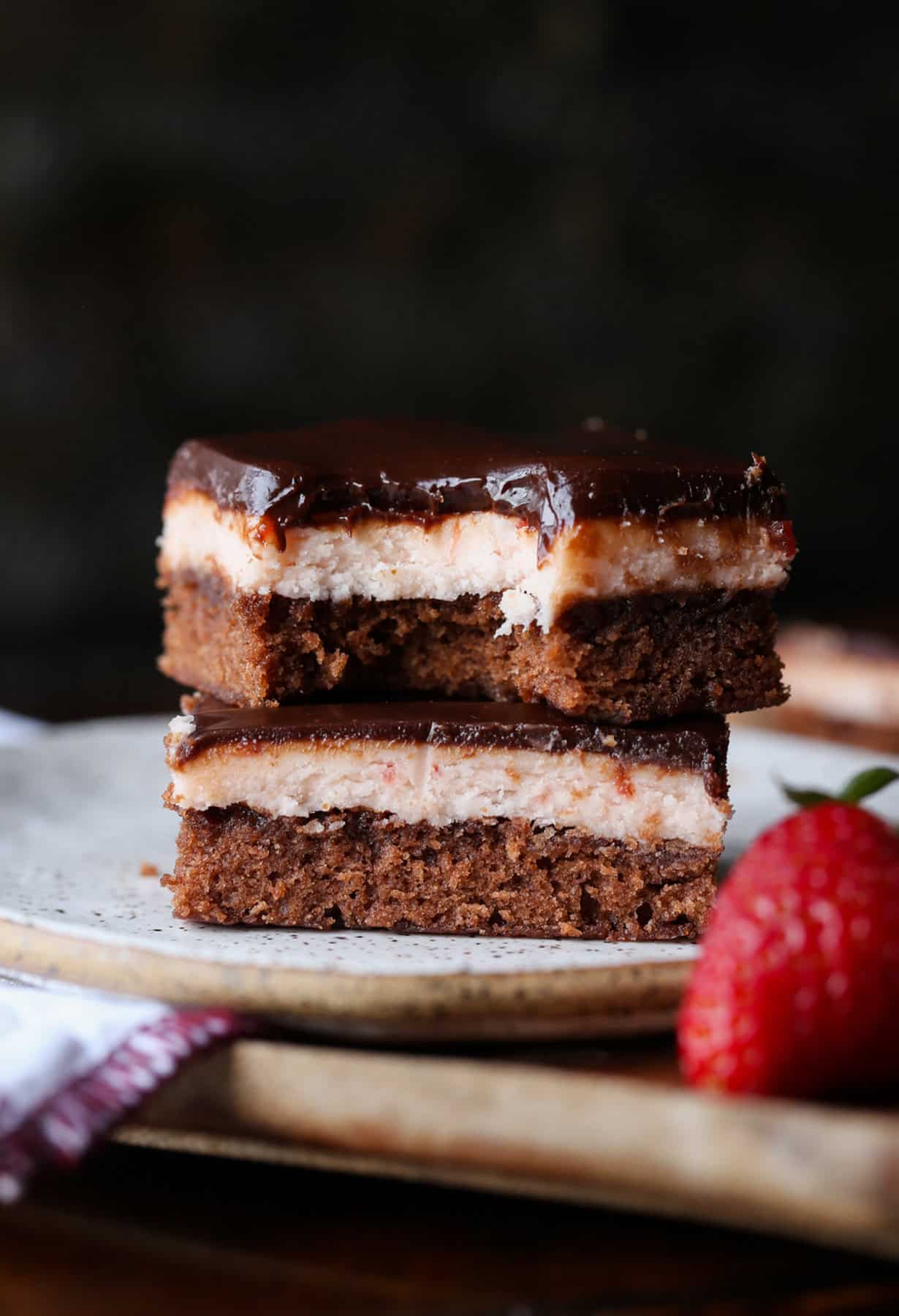 Take out a bite of the strawberry brownie stacked on the plate.