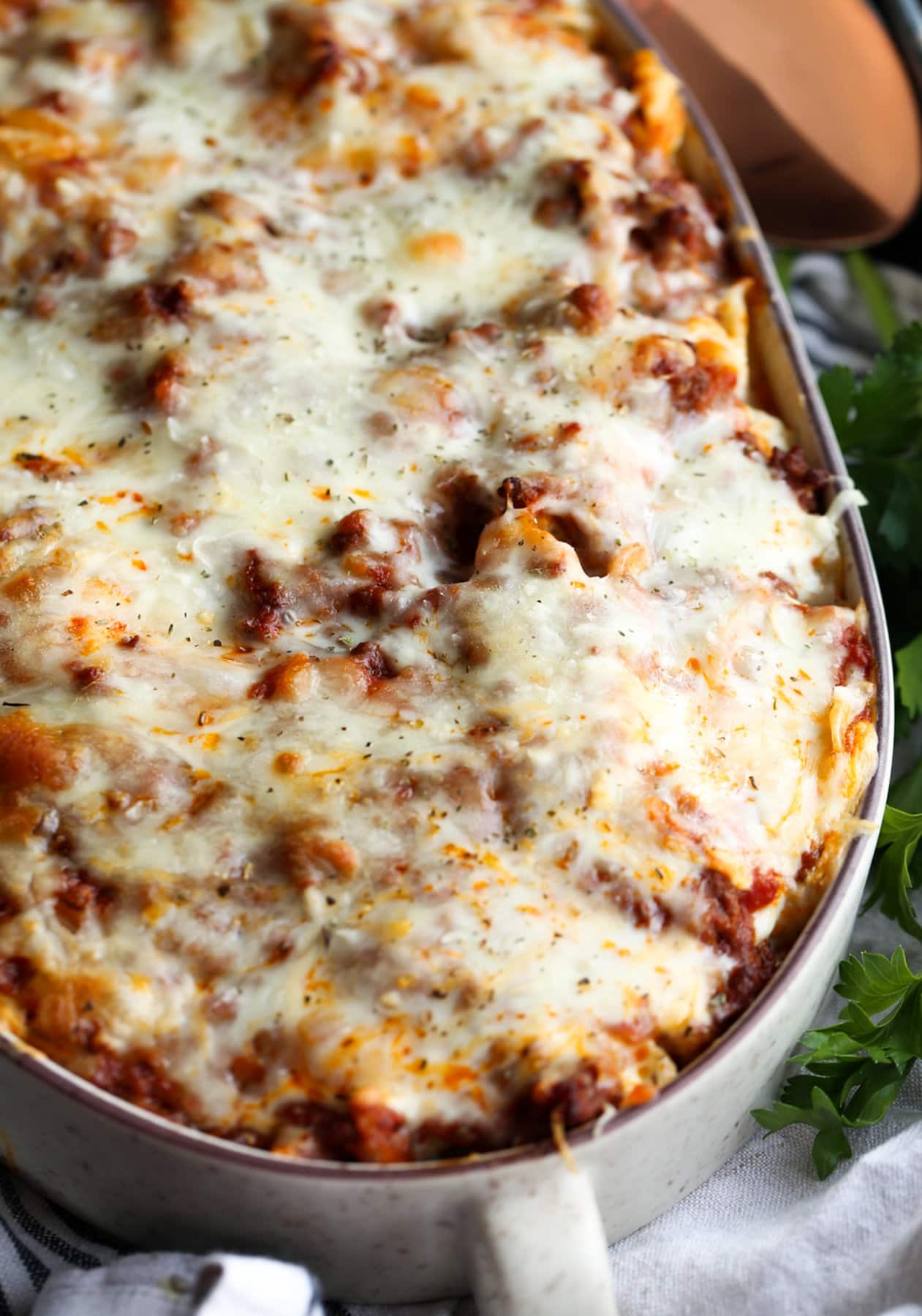 Baked shell pasta with meat and red sauce covered in mozzarella cheese baked in a casserole dish