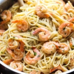 Pan full of shrimp and linguine.