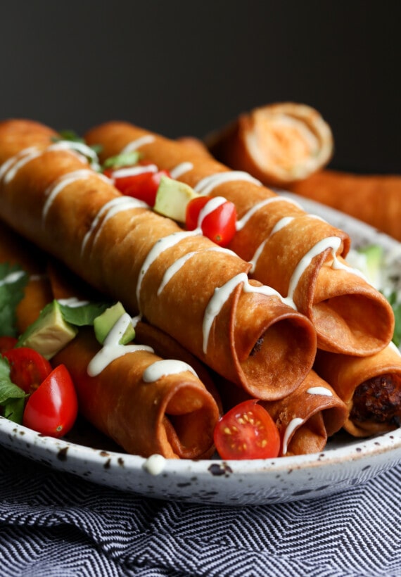 Flautas de Pollo stacked on a platter