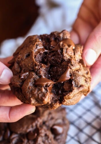 Breaking a chocolate chocolate chip cookie in half