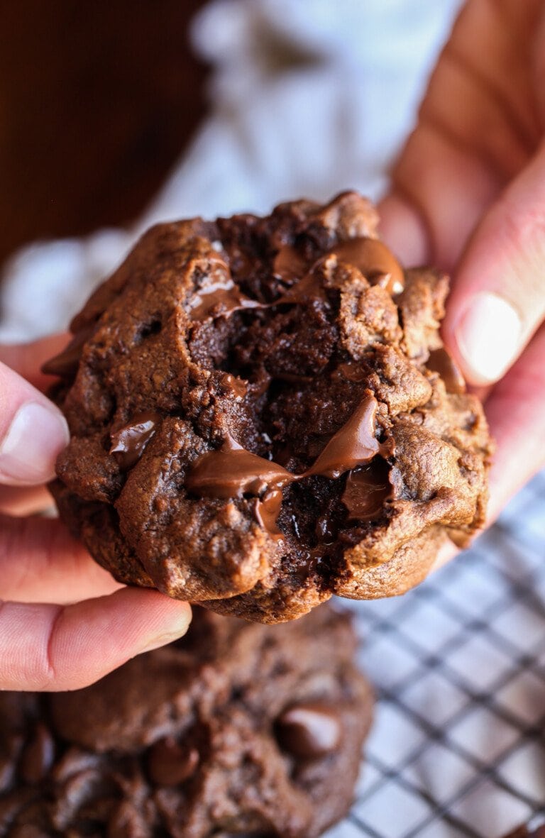 Breaking a chocolate chocolate chip cookie in half