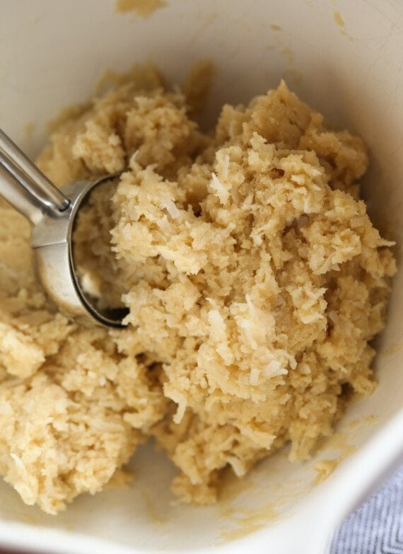 Coconut Cookie Dough in a bowl with a cookie scoop
