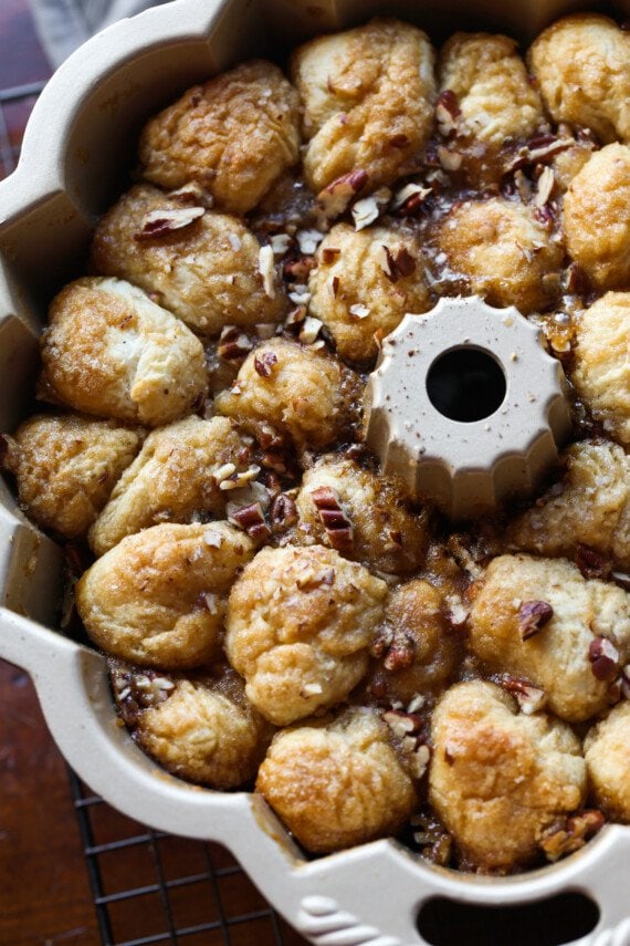 pieces of dough in a bundt pan baked with pecans