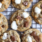 S'mores Cookies on a cooling rack with mini marshmallows and Hershey's chocolate