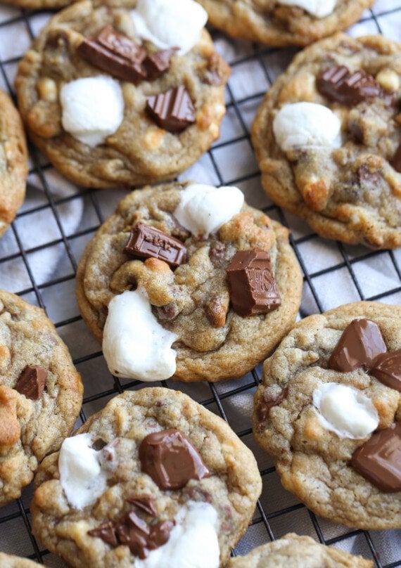 S'mores cookies on a wire rack topped with melted marshmallows and milk chocolate