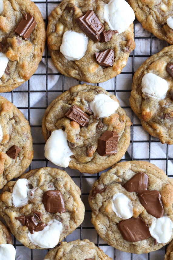 S'mores Cookies on a cooling rack with mini marshmallows and Hershey's chocolate