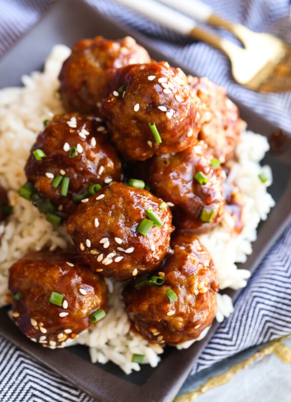 Sesame meatballs on a plate of rice.