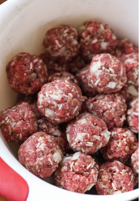 Uncooked porcupine meatballs in a bowl.
