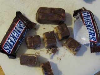 One Snack-Sized Snickers Bar Beside Another One That's Been Chopped Up