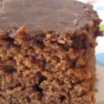 A Close-Up Shot of a Slice of Moist Coca Cola Cake Covered in Chocolate Coca Cola Frosting