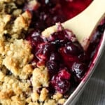 Blueberry Crisp in a baking dish with a spoon to serve