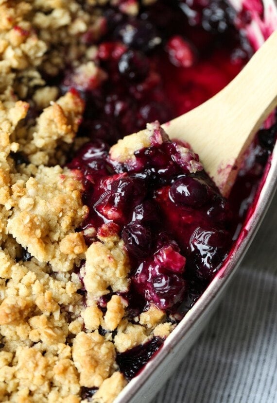 Blueberry Crisp in a baking dish with a spoon to serve