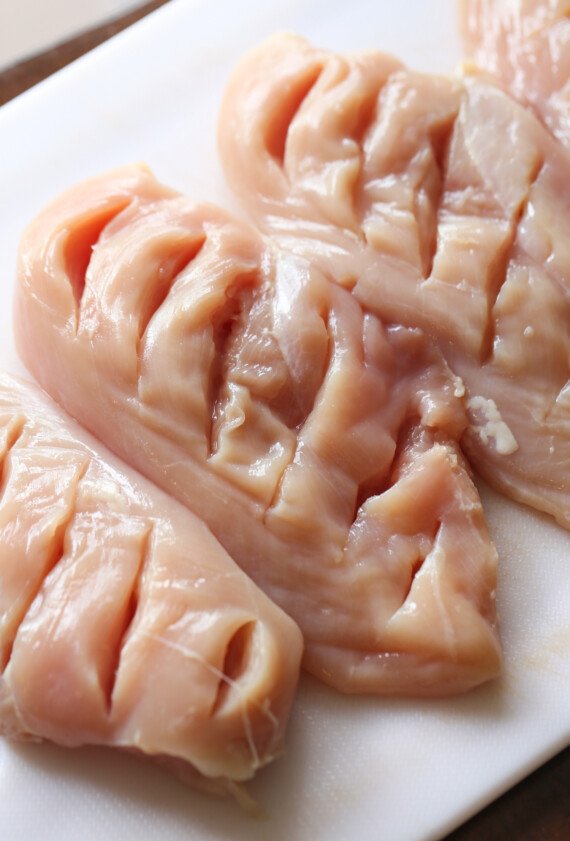 raw chicken breasts with slits cut into them