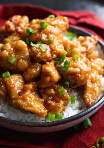 Orange chicken with chopped green onions.
